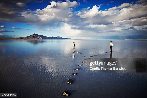 couple on separate pathways in water - alternative view stock-fotos und bilder