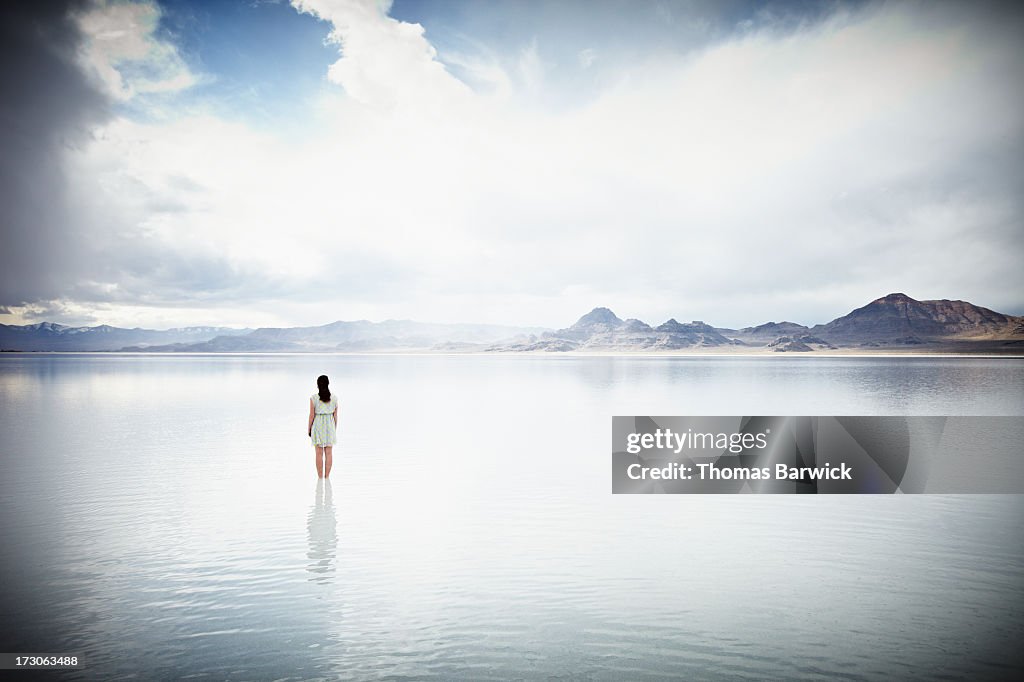 Woman standing in shallow water looking out