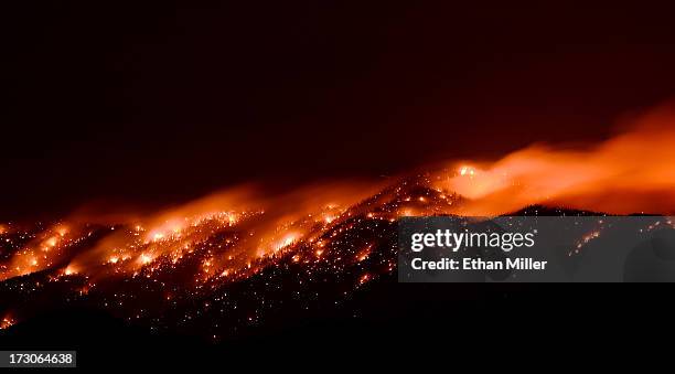 Smoke and flames from the Carpenter 1 fire are seen along a ridgeline in the Spring Mountains range early on July 6, 2013 in the Spring Mountains...