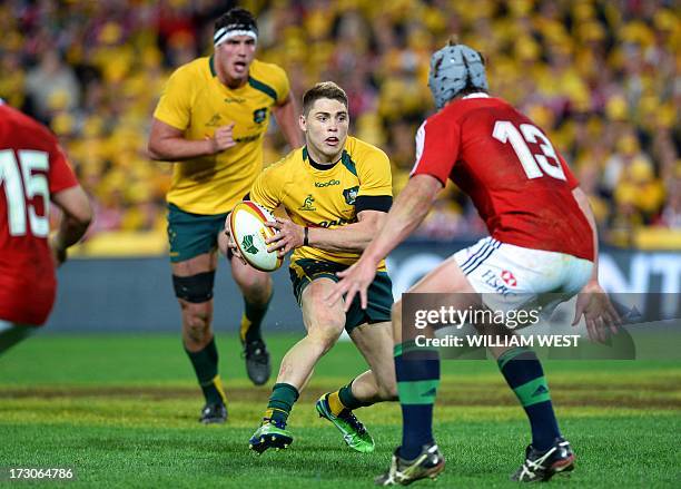 Australian Wallabies flyhalf James O'Connor takes on the British and Irish Lions defender Jonathan Davies as teammate Kane Douglas supports during...
