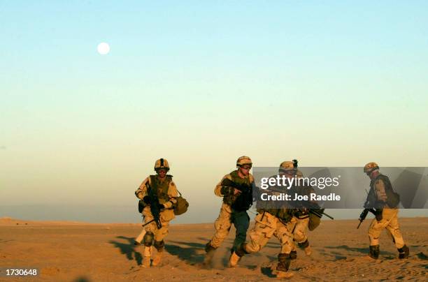Army soldiers of Task Force 315 of Fort Stewart, Georgia, run towards a trench as they participate in a clearing exercise January 17, 2003 in the...