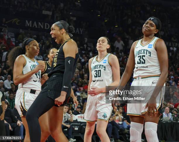 Ja Wilson of the Las Vegas Aces reacts after she scored a basket and drew a foul against Jonquel Jones of the New York Liberty as Betnijah Laney and...