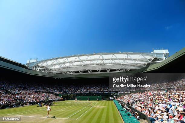 Sabine Lisicki of Germany serves on Centre Court during the Ladies' Singles final match against Marion Bartoli of France on day twelve of the...