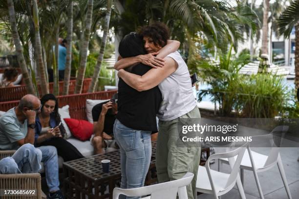 Two women hug each other at a hotel in the southern city of Eilat on October 17 which is hosting survivors from the Israeli kibbutz of Nir Oz near...