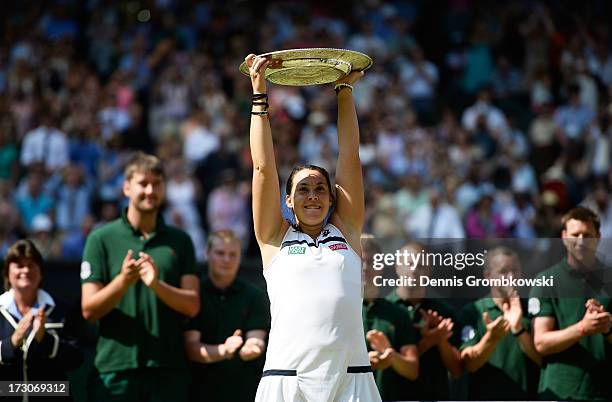 Marion Bartoli of France poses with the Venus Rosewater Dish trophy after her victory in the Ladies' Singles final match against Sabine Lisicki of...