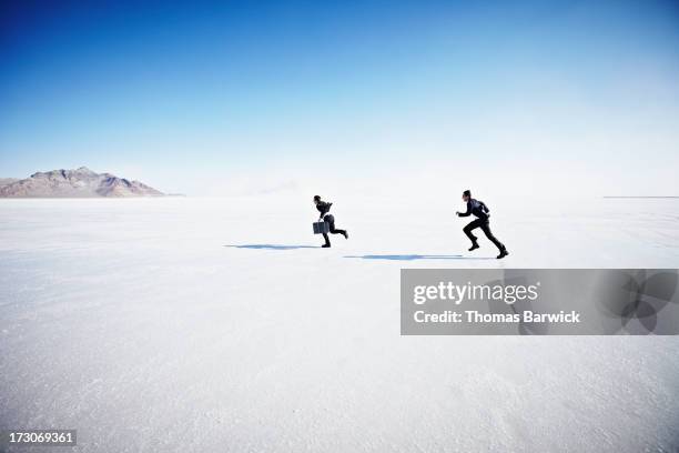 businessman with briefcase being chased - chasing stockfoto's en -beelden