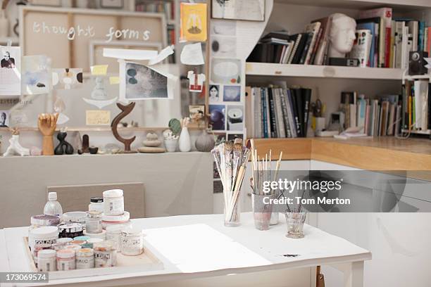 paintbrushes in jars in art studio - kunstatelier stockfoto's en -beelden