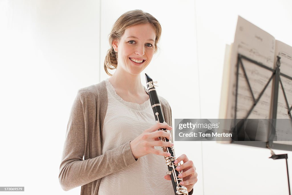 Smiling woman holding clarinet 