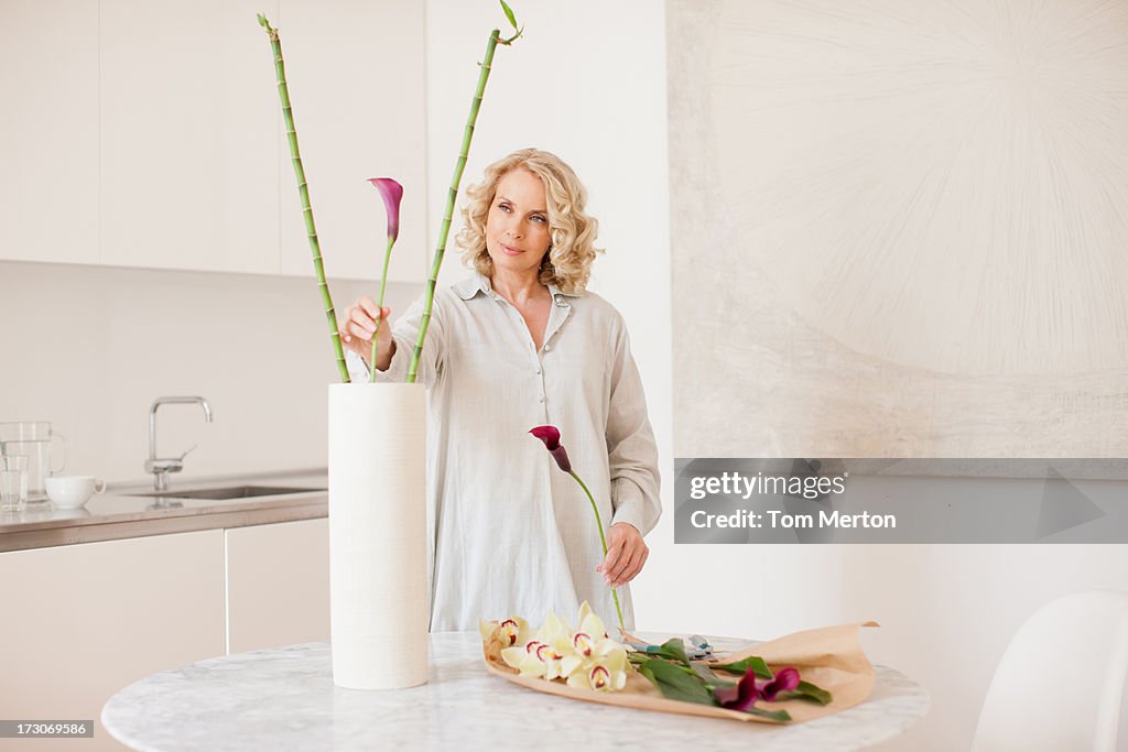 Woman arranging flowers in vase