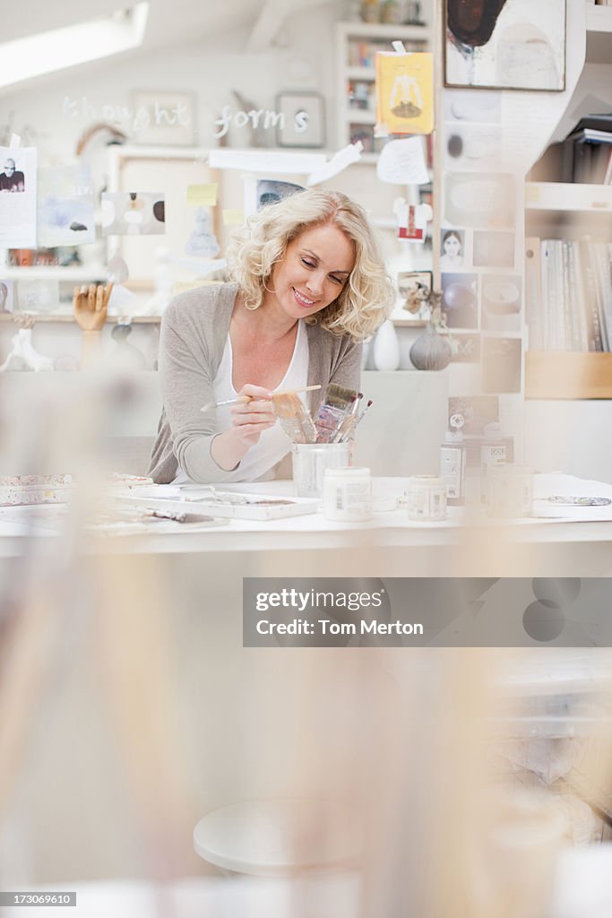 Woman looking at paintbrushes in art studio