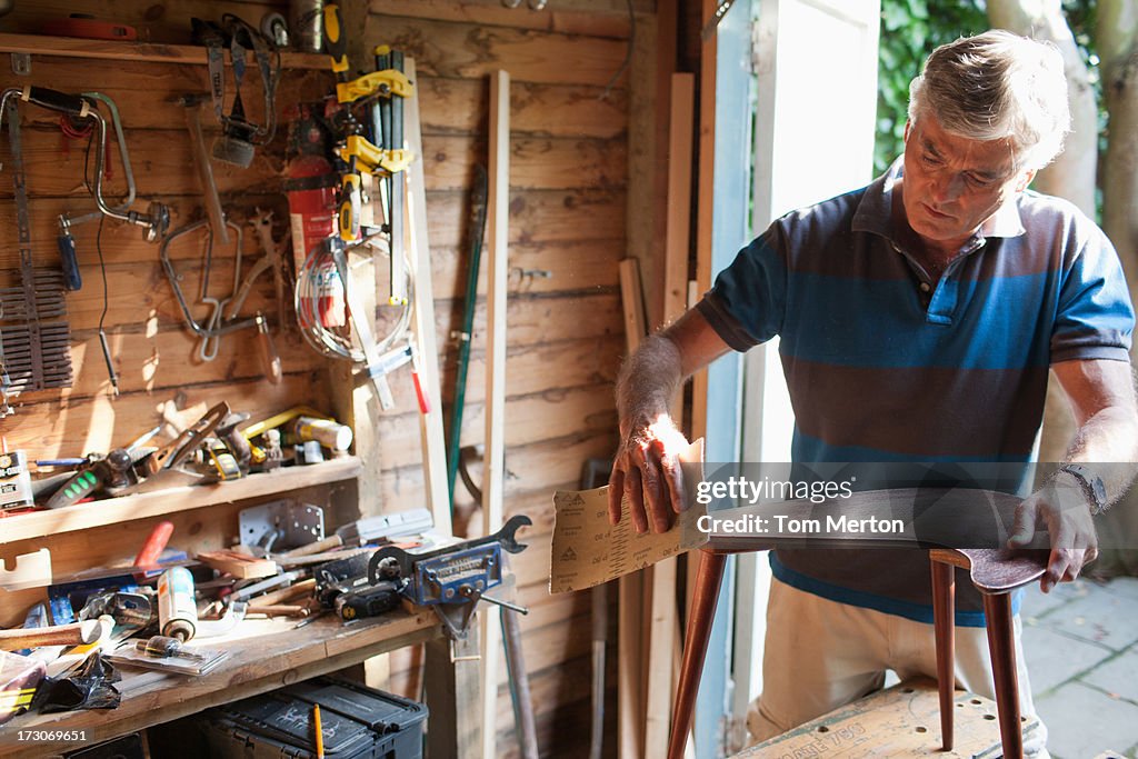 Man sanding wood in workshop