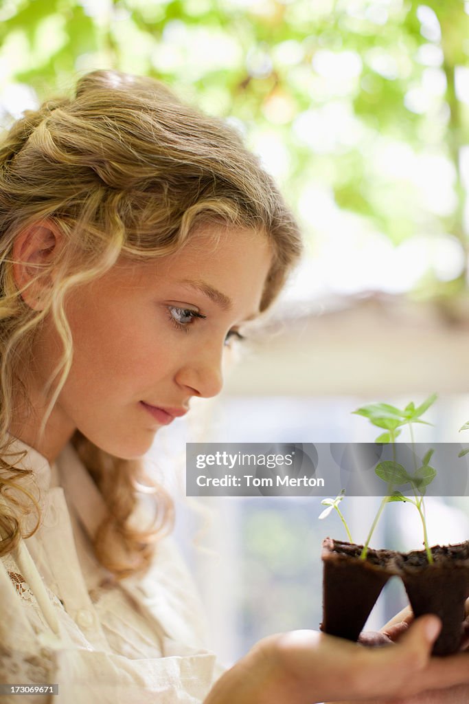 Girl looking at seedlings growing in plastic tray