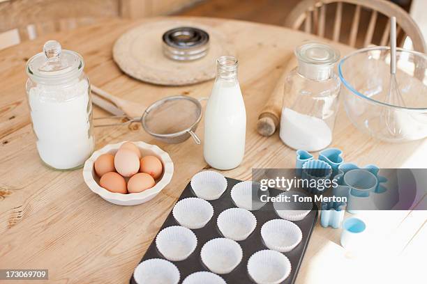 eggs and baking supplies on kitchen table - muffin tin stock pictures, royalty-free photos & images