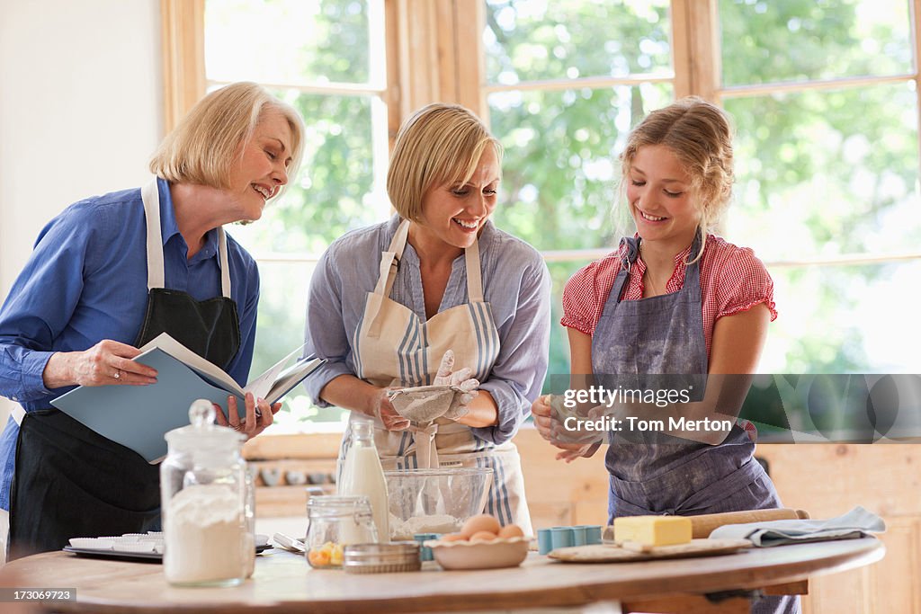 Multi-generation mujeres mirando en recetas y cocinar en la cocina