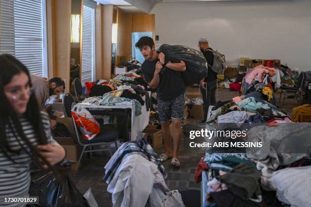 People receive clothes from donations at a hotel in the southern city of Eilat on October 17 which is hosting survivors from the Israeli kibbutz of...