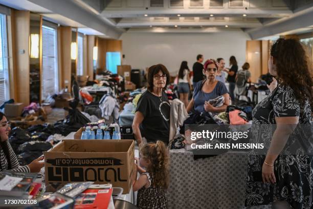 People receive clothes from donations at a hotel in the southern city of Eilat on October 17 which is hosting survivors from the Israeli kibbutz of...