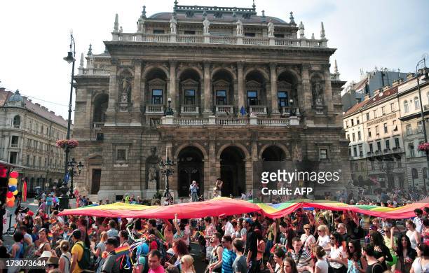 Participants hold a rainbow-flag during a gay pride march in front of the State Opera House in Budapest, Hungary on July 6, 2013. AFP PHOTO / STR +++...