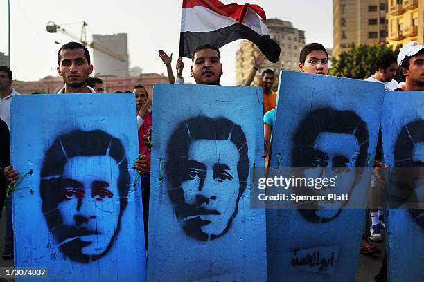 Protesters opposed to ousted Egyptian President Mohamed Morsi enter Tahrir Square carrying placards representing people killed during demonstrations...