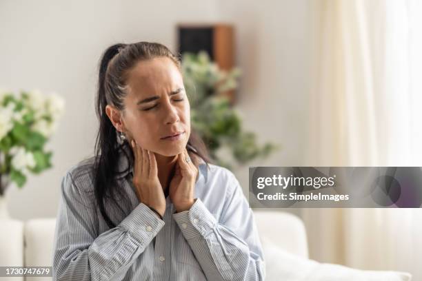women with thyroid gland problem with hands holding throat. - glándula de tiroides fotografías e imágenes de stock