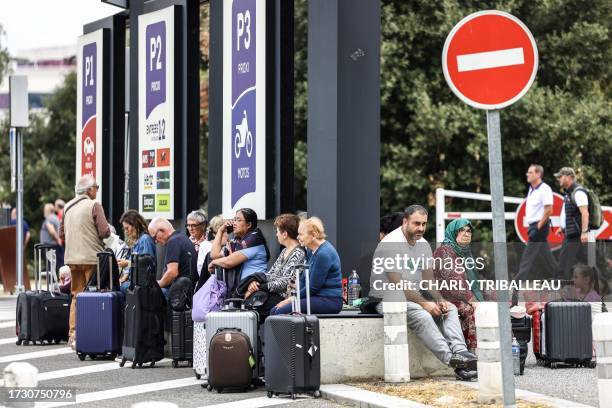 Passengers wait outside the Toulouse-Blagnac Airport in Blagnac, southwestern France, on October 18 after the airport has been evacuated. Six...