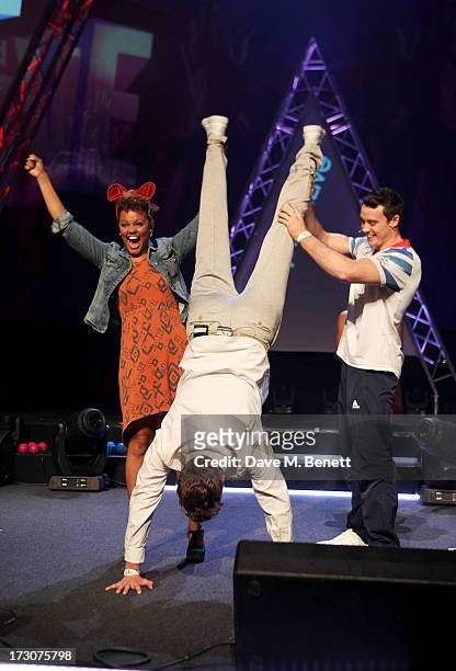 Rick Edwards does a handstand held up by Gemma Cairney and olympian Kristian Thomas on stage at vInspired Live, a youth social change event, at The...