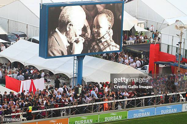 Giant screen projects images of former president Nelson Mandela during the 2013 Vodacom Durban July at Greyville Racecourse on July 06, 2013 in...