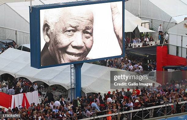 Giant screen projects images of former president Nelson Mandela during the 2013 Vodacom Durban July at Greyville Racecourse on July 06, 2013 in...