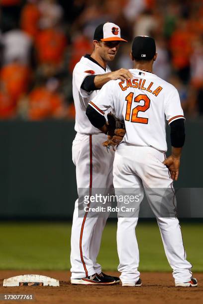 Shortstop J.J. Hardy congratulates teammate Alexi Casilla of the Baltimore Orioles after the Orioles defeated the Cleveland Indians at Oriole Park at...