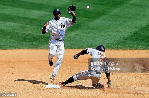 Alexi Casilla of the Baltimore Orioles steals second base ahead of a high throw to Eduardo Nunez of the New York Yankees at Yankee Stadium on July 6,...
