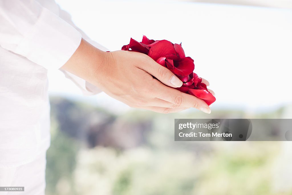 Woman holding handful of flower petals