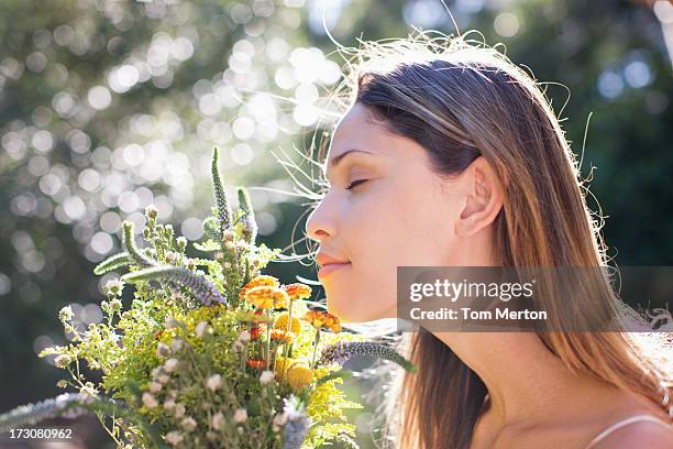 tranquila mujer oliendo bouquet - oler fotografías e imágenes de stock