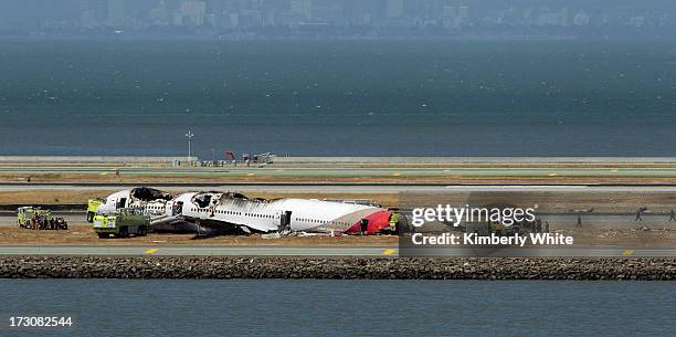 Investigators surround the remains of a Boeing 777 airplane on the tarmac after it crashed while landing at San Francisco International Airport July...