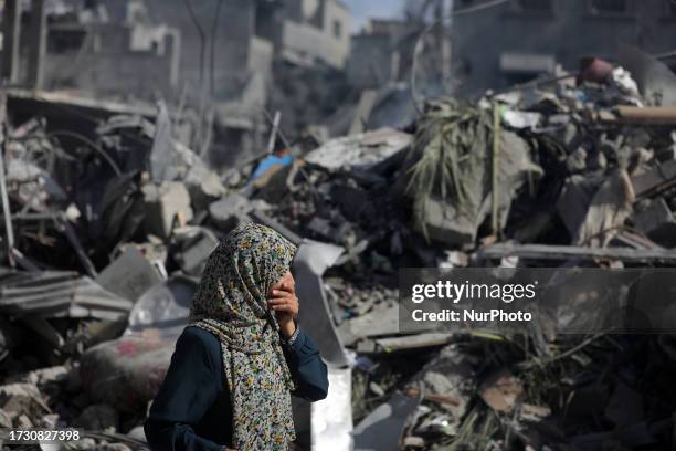 Palestinians gather at a site of Israeli strikes on houses in Bureij camp in the central Gaza Strip, October 18, 2023.