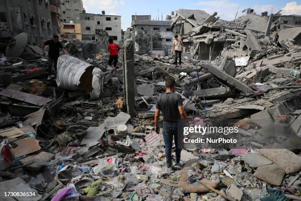 Palestinians gather at a site of Israeli strikes on houses in Bureij camp in the central Gaza Strip, October 18, 2023.
