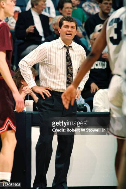 University of Connecticut basketball coach Geno Auriemma stand with his hands on his hips on the sideline during a game, Storrs, Connecticut, 1994.