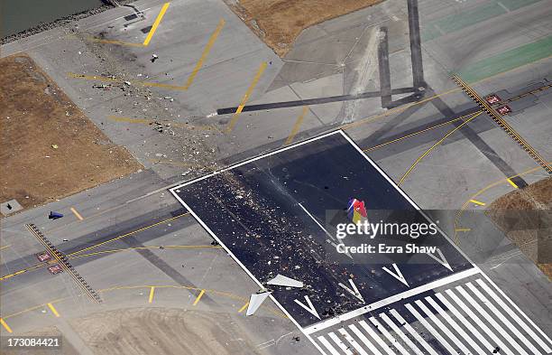 Close up of the runway and debris of a Boeing 777 airplane that burned on the runway after it crash landed at San Francisco International Airport...