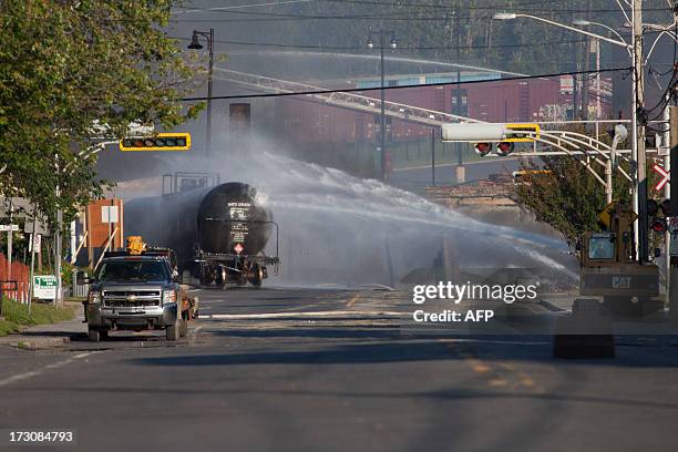 Firefighters douse a blaze after a freight train loaded with oil derailed in Lac Megantic in Canada's Quebec province on July 6 sparking explosions...