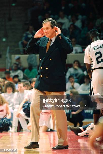 University of Connecticut basketball coach Jim Calhoun holds his hands to his ears on the sidelines during a game, Hartford, Connecticut, 1989.