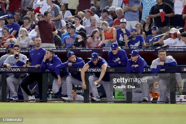 Members of the Los Angeles Dodgers look on from the dugout in the ninth inning against the Arizona Diamondbacks during Game Three of the Division...