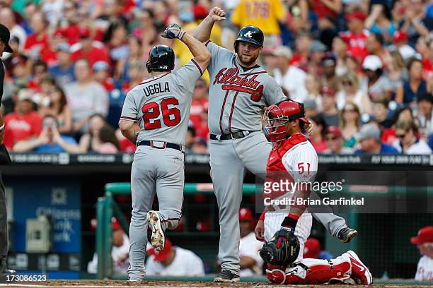 Brian McCann of the Atlanta Braves congratulates Dan Uggla after Uggla hit a two-run home run in the second inning of the game against the...