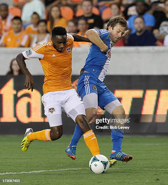 Warren Creavalle of the Houston Dynamo is pressured by Antoine Hoppenot of the Philadelphia Union in the first half at BBVA Compass Stadium on July...