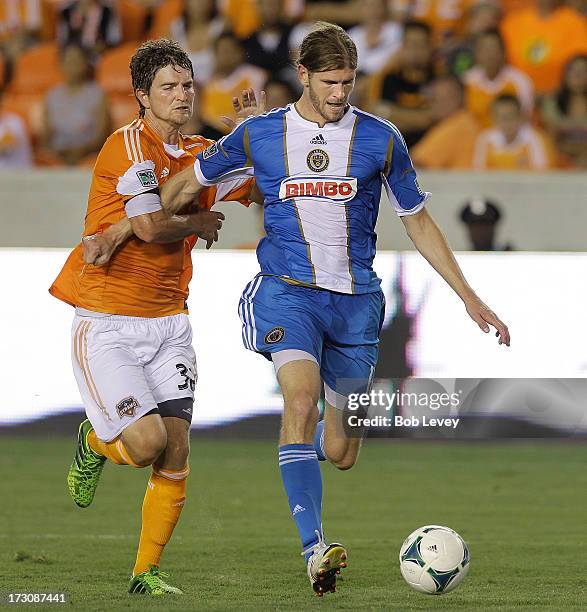 Aaron Wheeler of the Philadelphia Union beats Bobby Boswell of the Houston Dynamo to the ball as he puts it on goal in the first half at BBVA Compass...