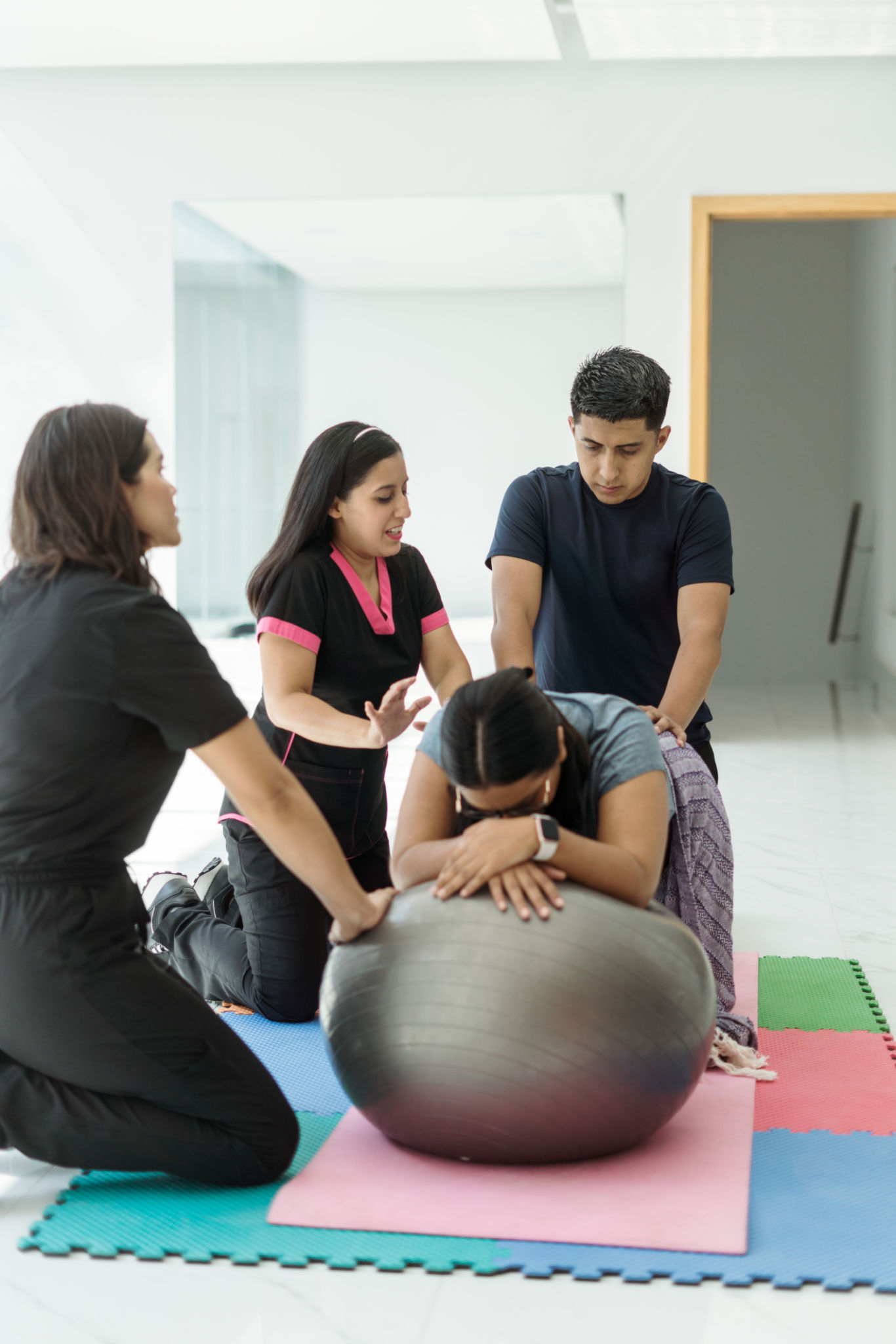 Instructor explains to young man how to help with exercises that provide comfort to his pregnant wife Instructor explains to young man how to help with exercises that provide comfort to his pregnant wife
