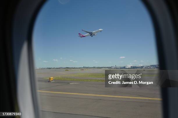 Qantas domestic Boeing 737-800 aircraft takes off at Sydney's Kingsford Smith Airport and as seen from a QantasLink aircraft, a Q-400 on October 09,...
