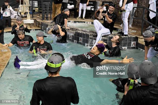 Lourdes Gurriel Jr. #12 of the Arizona Diamondbacks dives into the pool after beating the Los Angeles Dodgers 4-2 in Game Three of the Division...