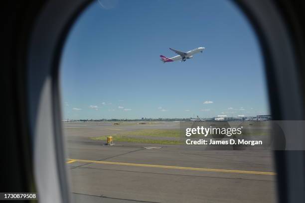 Qantas domestic Boeing 737-800 aircraft takes off at Sydney's Kingsford Smith Airport and as seen from a QantasLink aircraft, a Q-400 on October 09,...