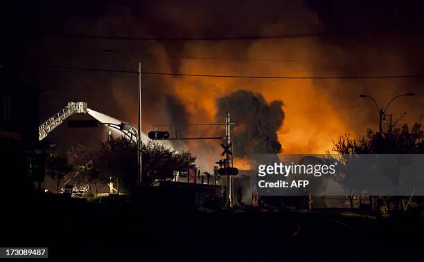 Firefighters douse blazes after a freight train loaded with oil derailed in Lac-Megantic in Canada's Quebec province on July 6 sparking explosions...
