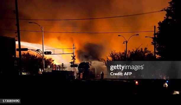 Firefighters douse blazes after a freight train loaded with oil derailed in Lac-Megantic in Canada's Quebec province on July 6 sparking explosions...