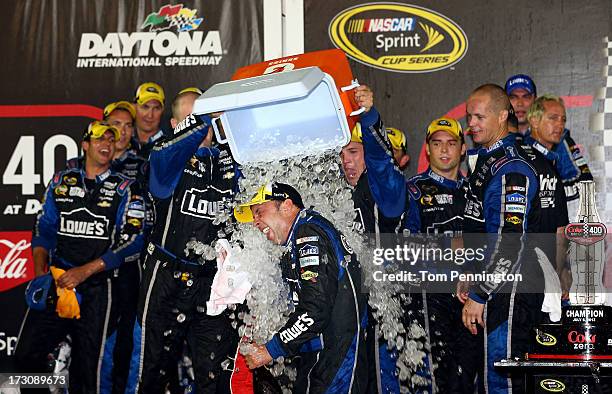 Crew mebers of the Lowe's Dover White Chevrolet driven by Jimmie Johnson , dump an ice cooler over crew chief Chad Knaus in victory lane after...