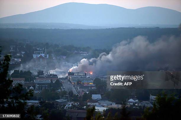 Firefighters douse blazes after a freight train loaded with oil derailed in Lac-Megantic in Canada's Quebec province on July 6 sparking explosions...